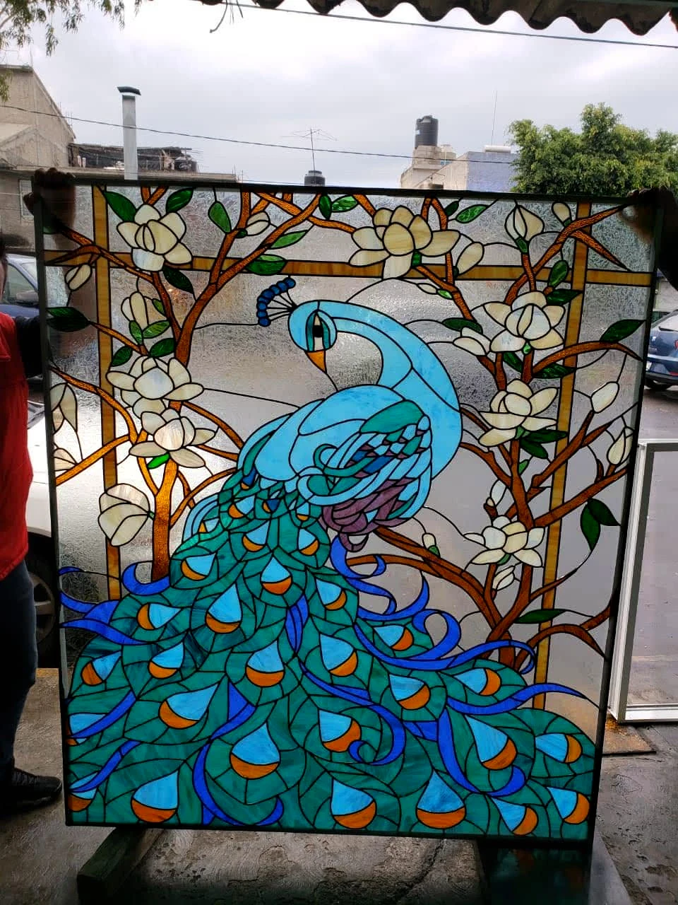 Vitral de un pavo real azul