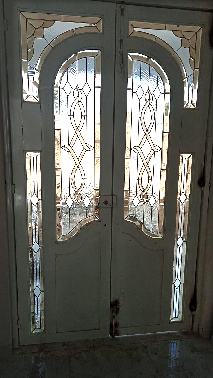 Puerta doble blanca con vitrales geométricos