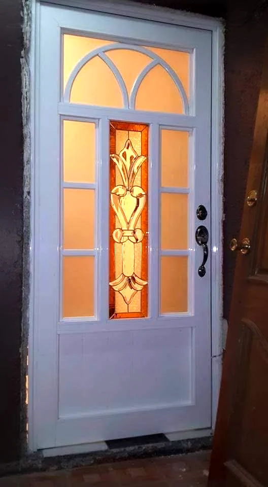 Puerta blanca con vitral central en tonos cálidos